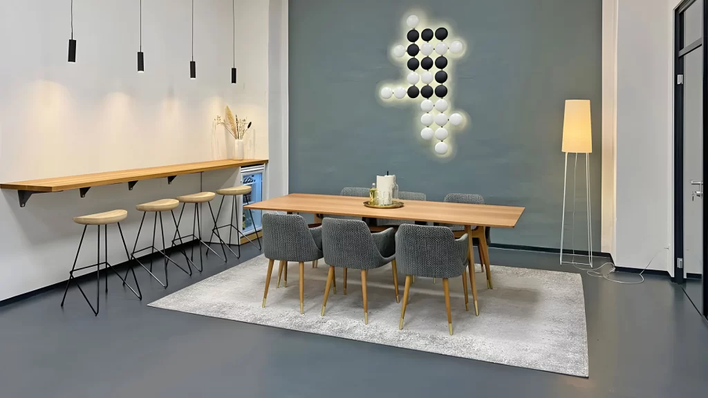 Modern eigerichtetes Zimmer mit Teppich, Bar und großem Esstisch in Grautönen