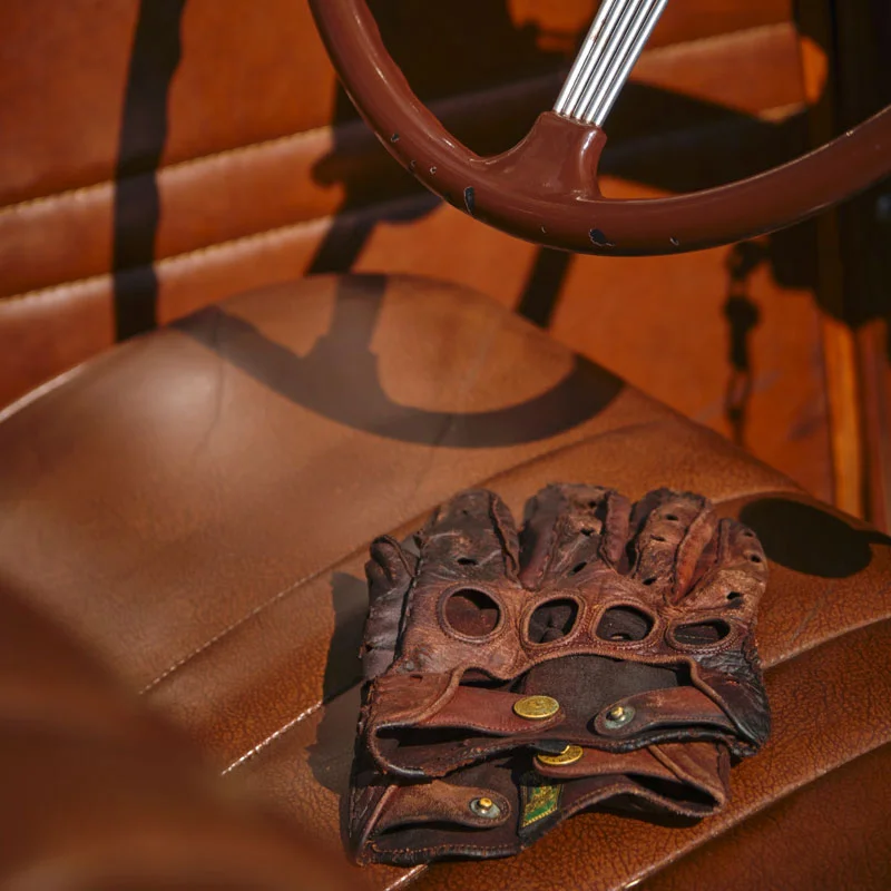 Nahaufnahme von autositzen aus leder mit lederhandschuhen draufliegend