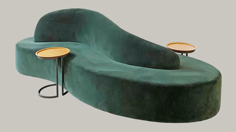 Maßmöbel aus grünem Samtstoff mit zwei kleinen Beistelltischen