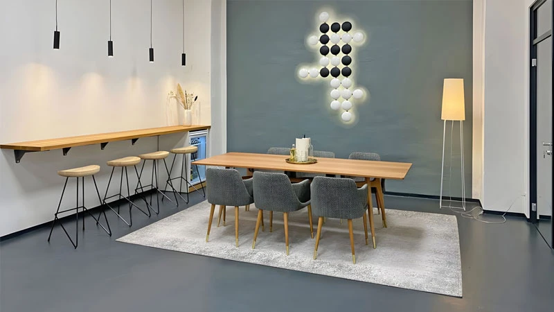 Modernes eingerichtetes Zimmer mit Teppich, Bar und großem Esstisch in Grautönen