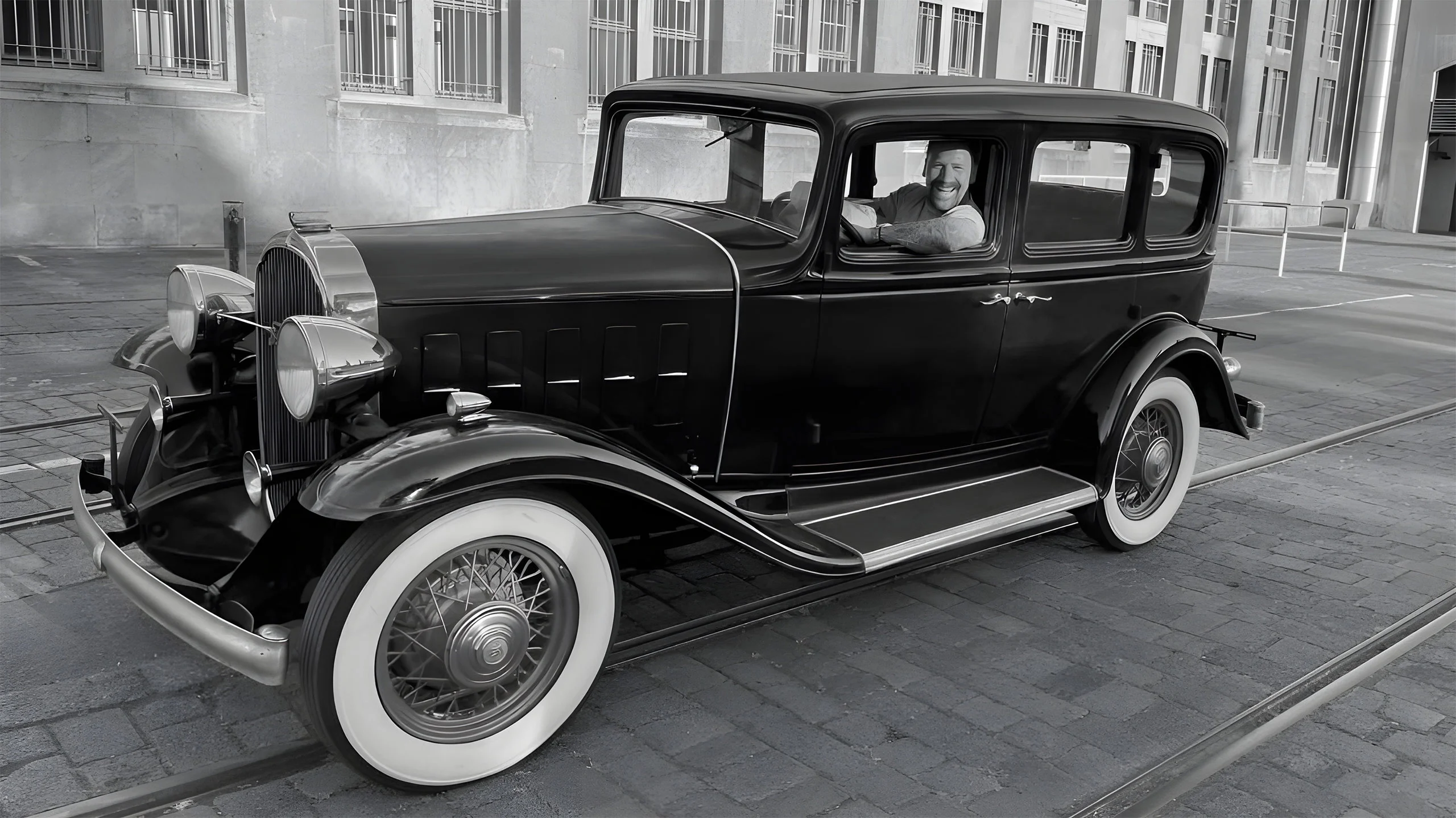 Mann im oldtimer mit runtergelassenen fenstern